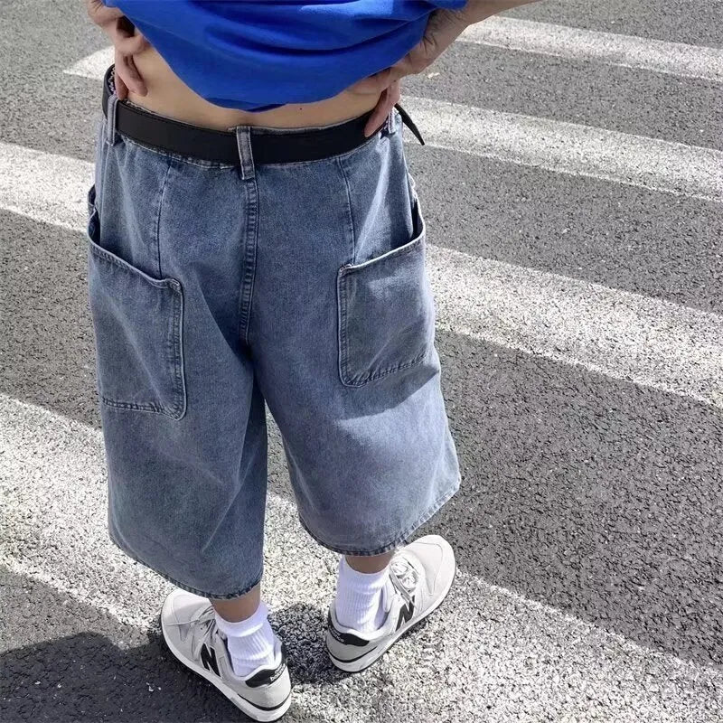 Blue washed denim shorts for men with high waist and cropped pirate-style legs on a plain background.
