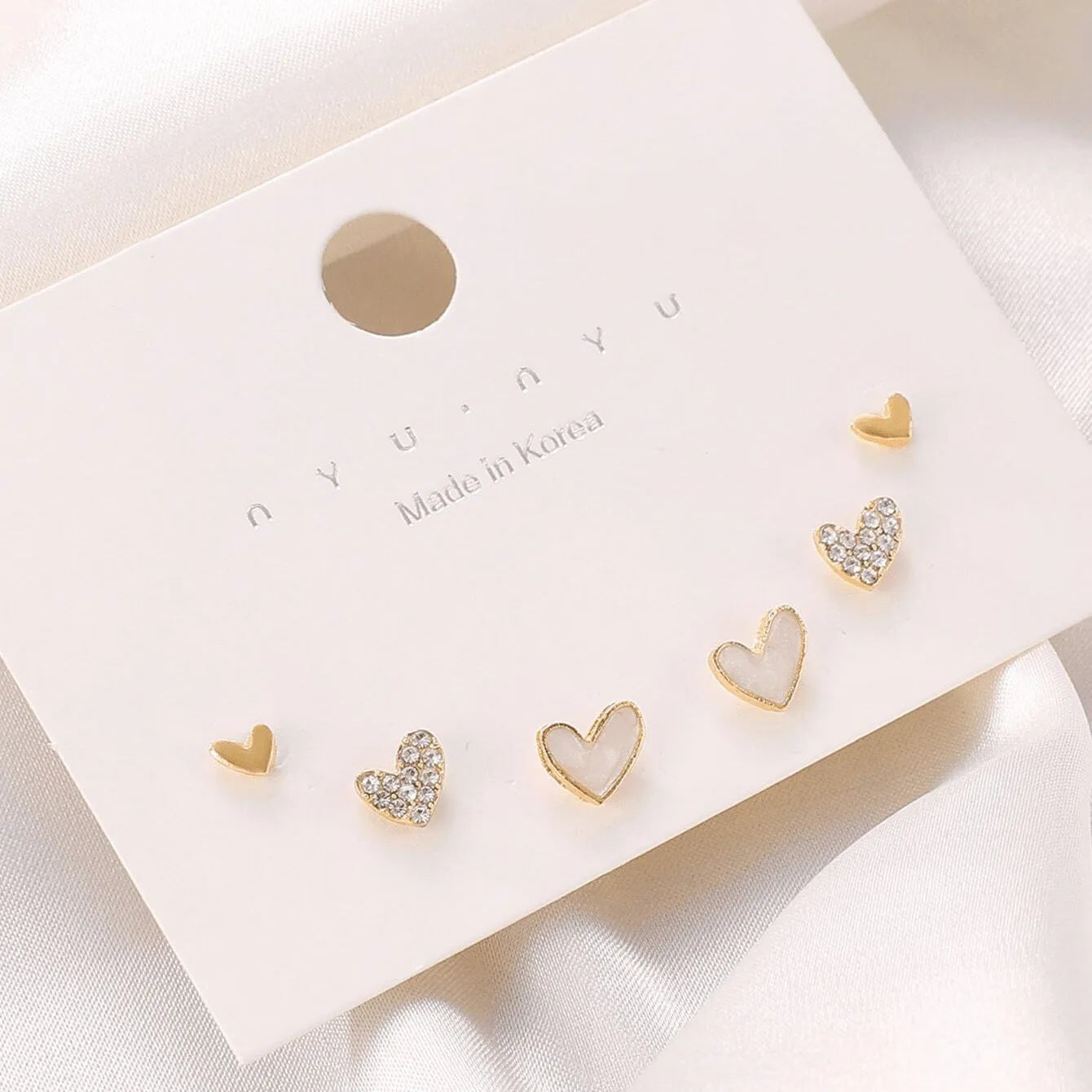 Three pairs of heart-shaped alloy earrings with love motifs in four colour options
