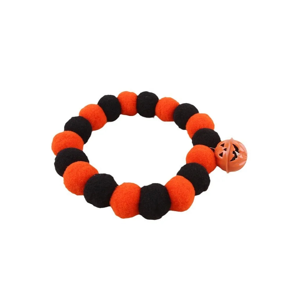 Orange Halloween cat collar with black pumpkin print and a silver bell, shown with an adjustable buckle.