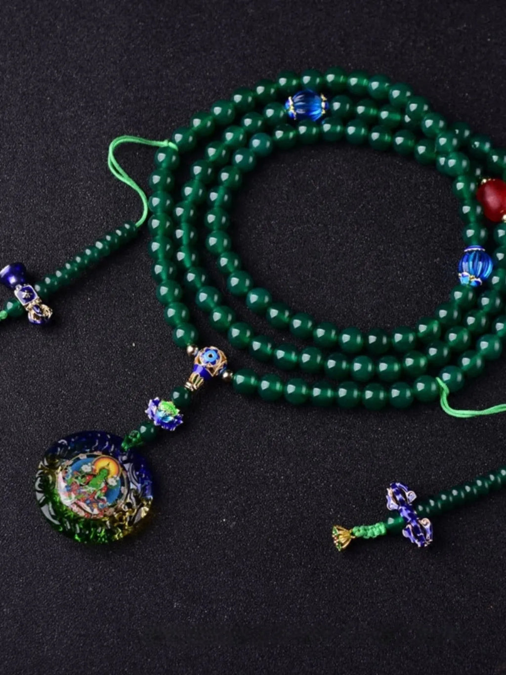 Handmade green agate bracelet with a detailed thangka pendant and multi-circle bead design.