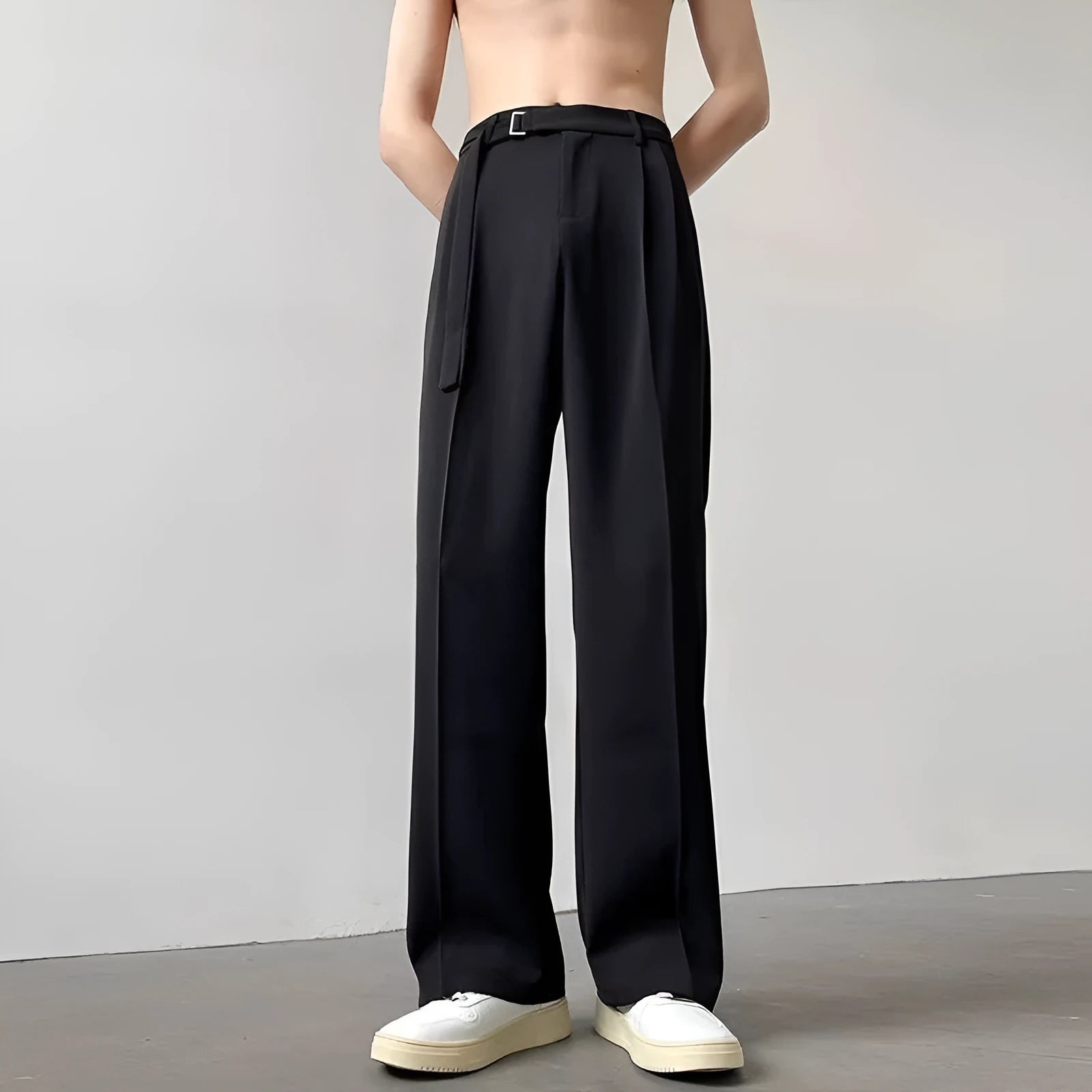 A pair of thin, black wide leg trousers with a straight cut and loose fit, laid flat.