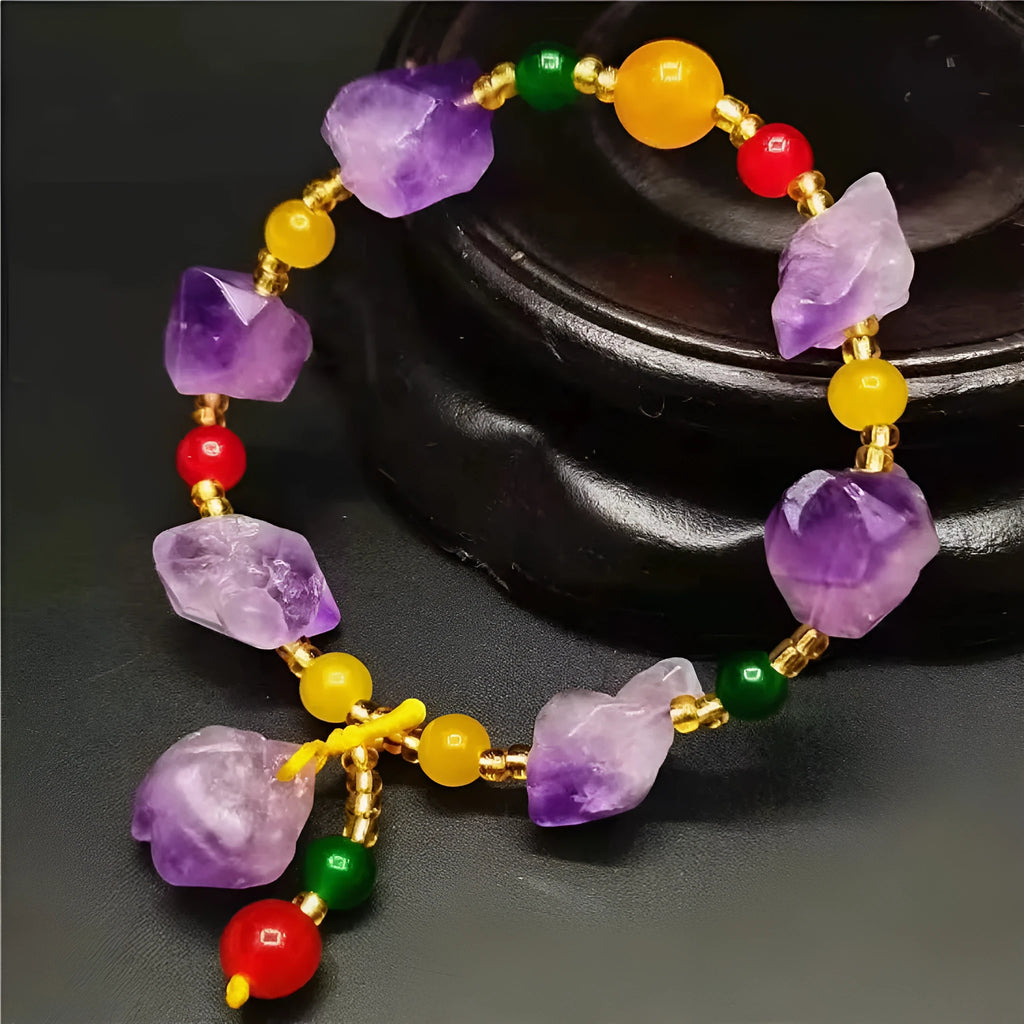 Women's amethyst bracelet with natural shaped beads and a fu character charm on an adjustable band.