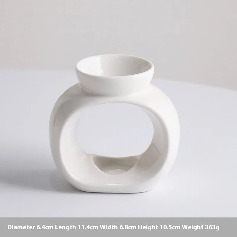 White ceramic Nordic-style aromatherapy stove ornament on a wooden surface.