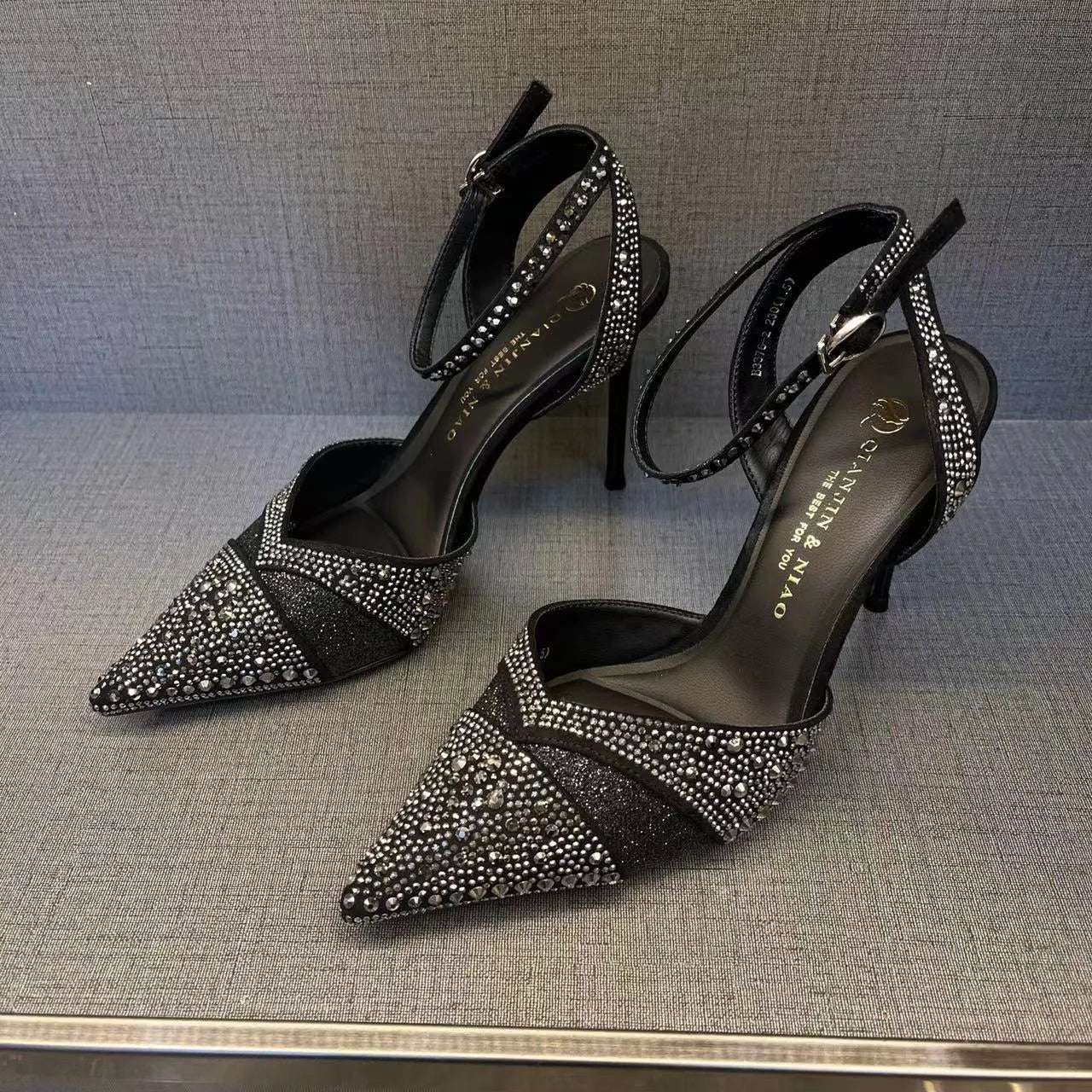 Women's silver and black hollow high heels with red sole and pointed toe design