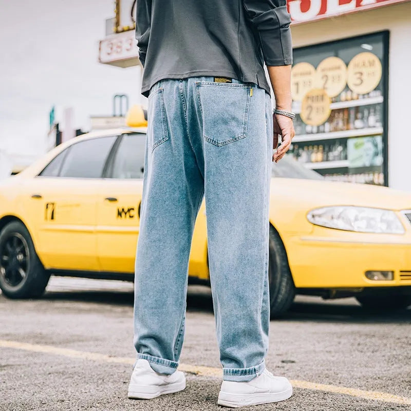 Men's loose straight-leg jeans in cotton denim, shown in dark blue, with a zipper fly and mid-rise waist.