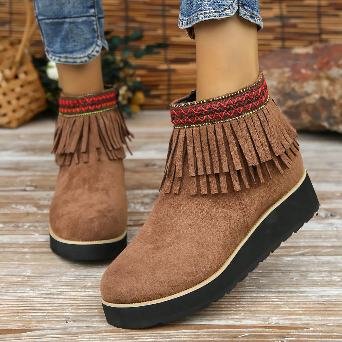 Women's dark brown suede ankle boots with a wedge heel, side zip, and decorative tassel detail.