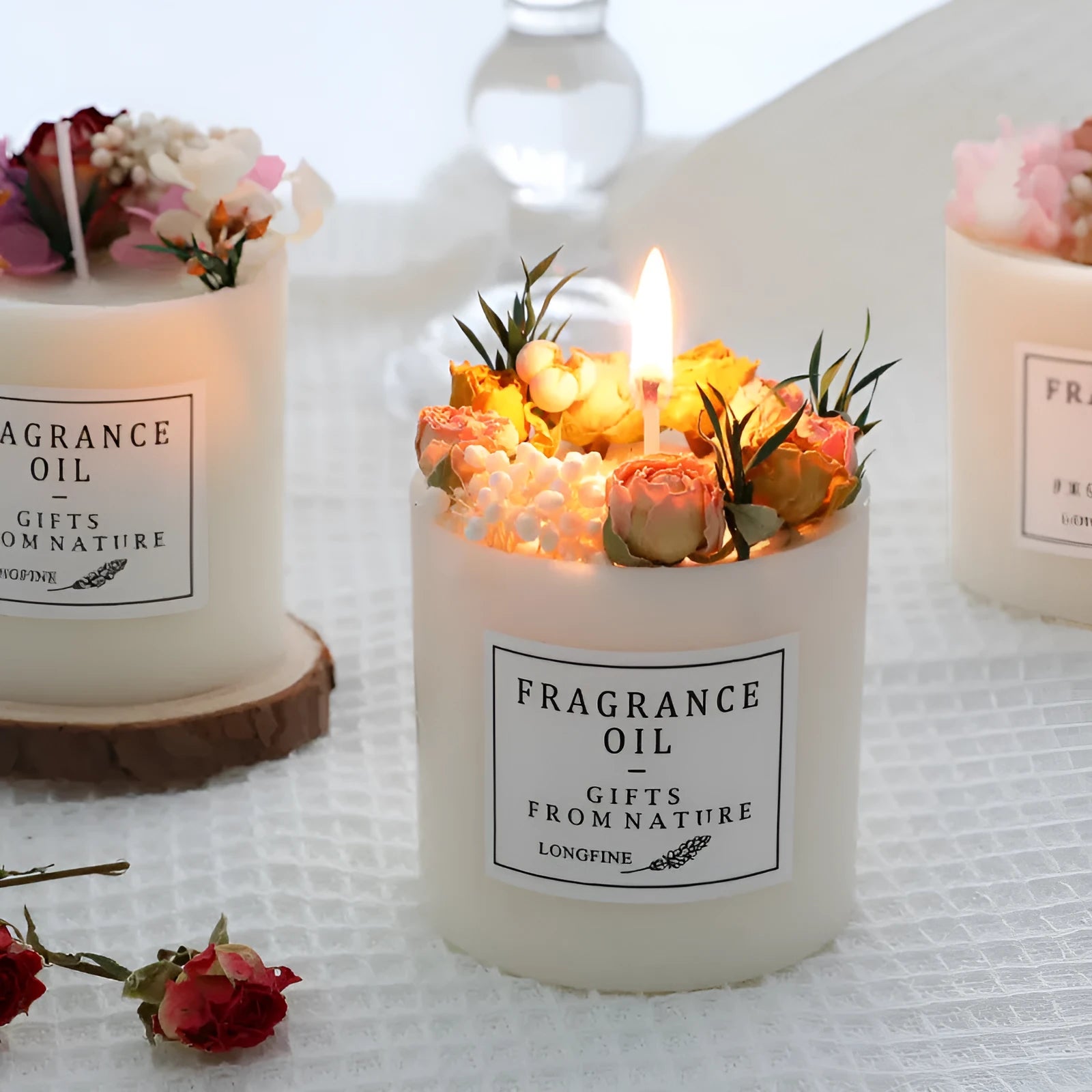 Decorative aromatherapy candle with dried flowers embedded in solid wax, shown with optional wooden chip base.