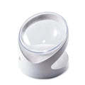 Clear plastic tilted cat food bowl on a flat surface