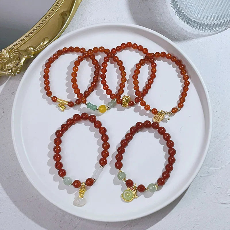 A red agate bracelet for women with Chinese style dragon and lucky bag motifs.