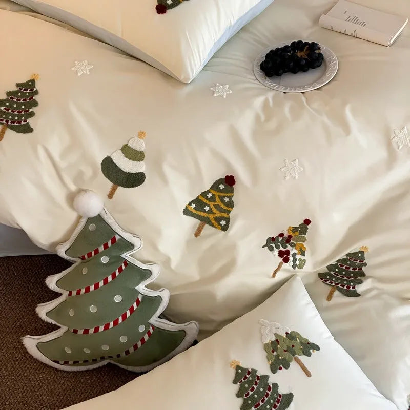 Four-piece cotton bedding set with Christmas tree towel embroidery pattern showing duvet cover, bed sheet, and pillowcases