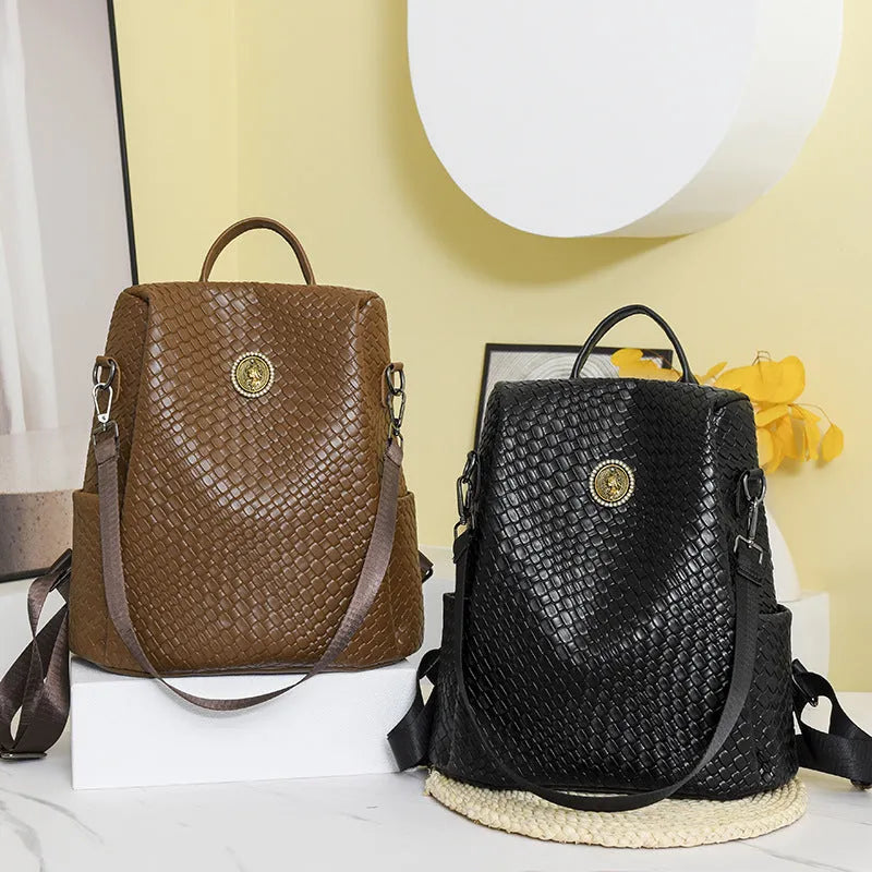 Women's black anti-theft backpack with woven detailing and multiple zipped compartments.