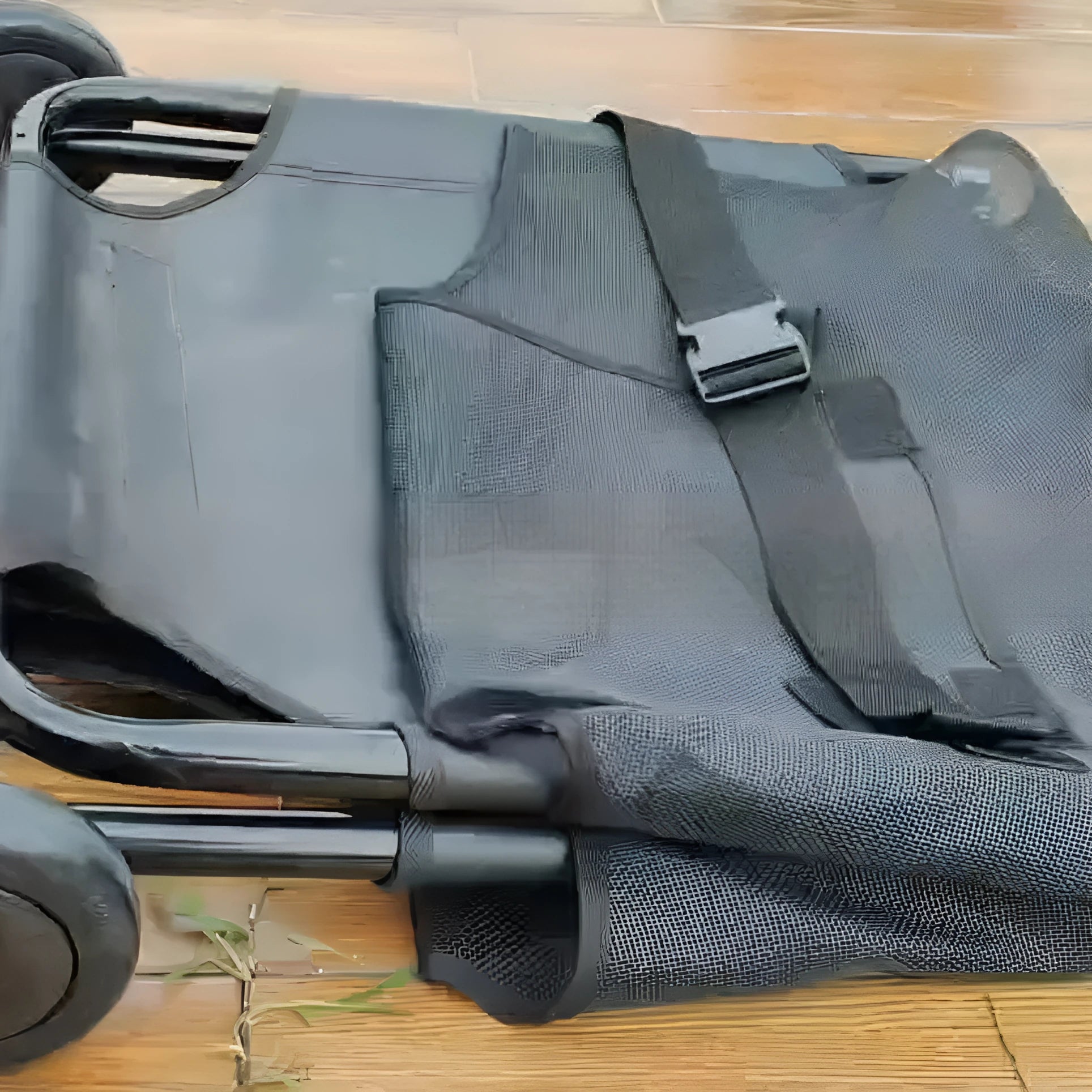 Large black aluminium alloy foldable pet stretcher unfolded on the ground for dog emergency transport.