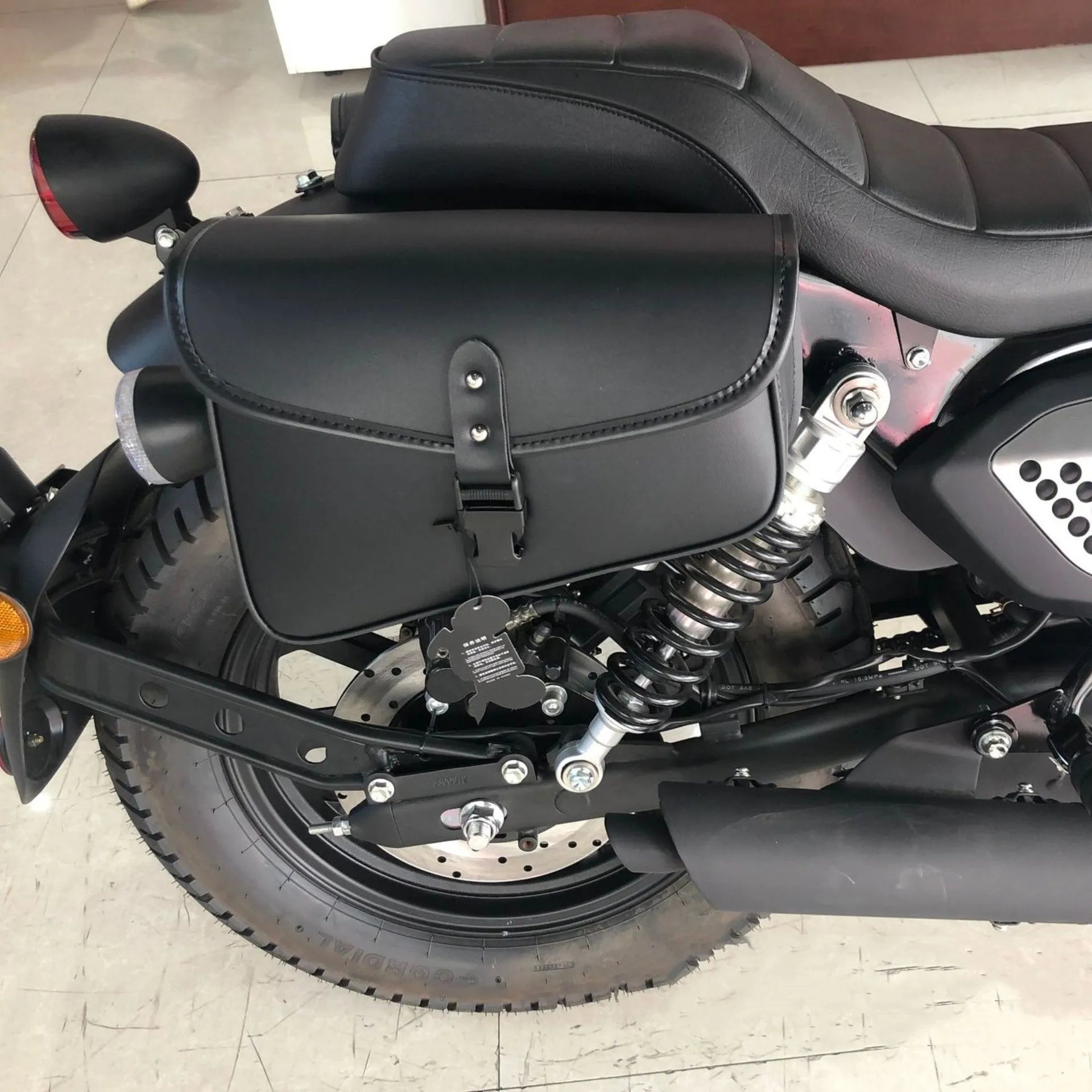 Black PU leather motorcycle swingarm bag mounted to Sportster motorcycle showing dimensions and storage capacity