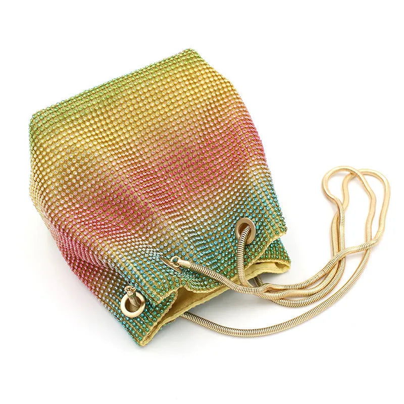 Colourful rhinestone fabric bucket bag with a sparkling jewelled shoulder strap on a white background