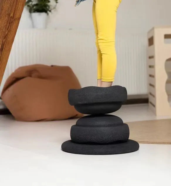 Children's plastic surf-shaped balance board in mixed wood colour and solid black option.