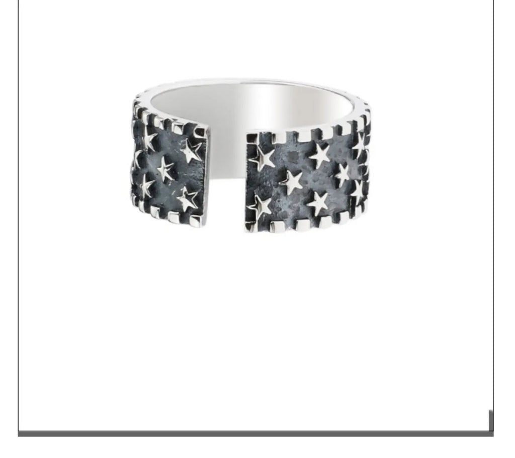 Adjustable open-back sterling silver ring with a raised five-pointed star geometric pattern.