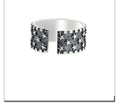 Adjustable open-back sterling silver ring with a raised five-pointed star geometric pattern.