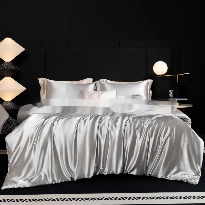 Solid colour silk bedding four-piece set shown in twilight blue on a bed.