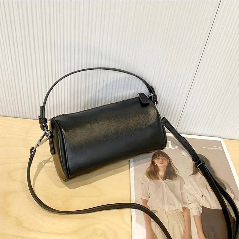 Soft vegetable-tanned leather crossbody phone bag in cylindrical shape with adjustable strap.