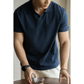 Blue short-sleeved cotton blend polo shirt for men on a hanger, showing regular fit and button placket.