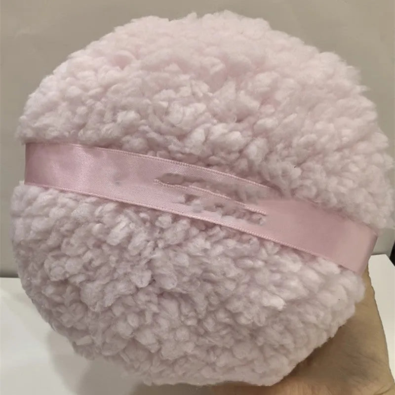 Oversized white plush powder puff measuring 150mm by 75mm for makeup application