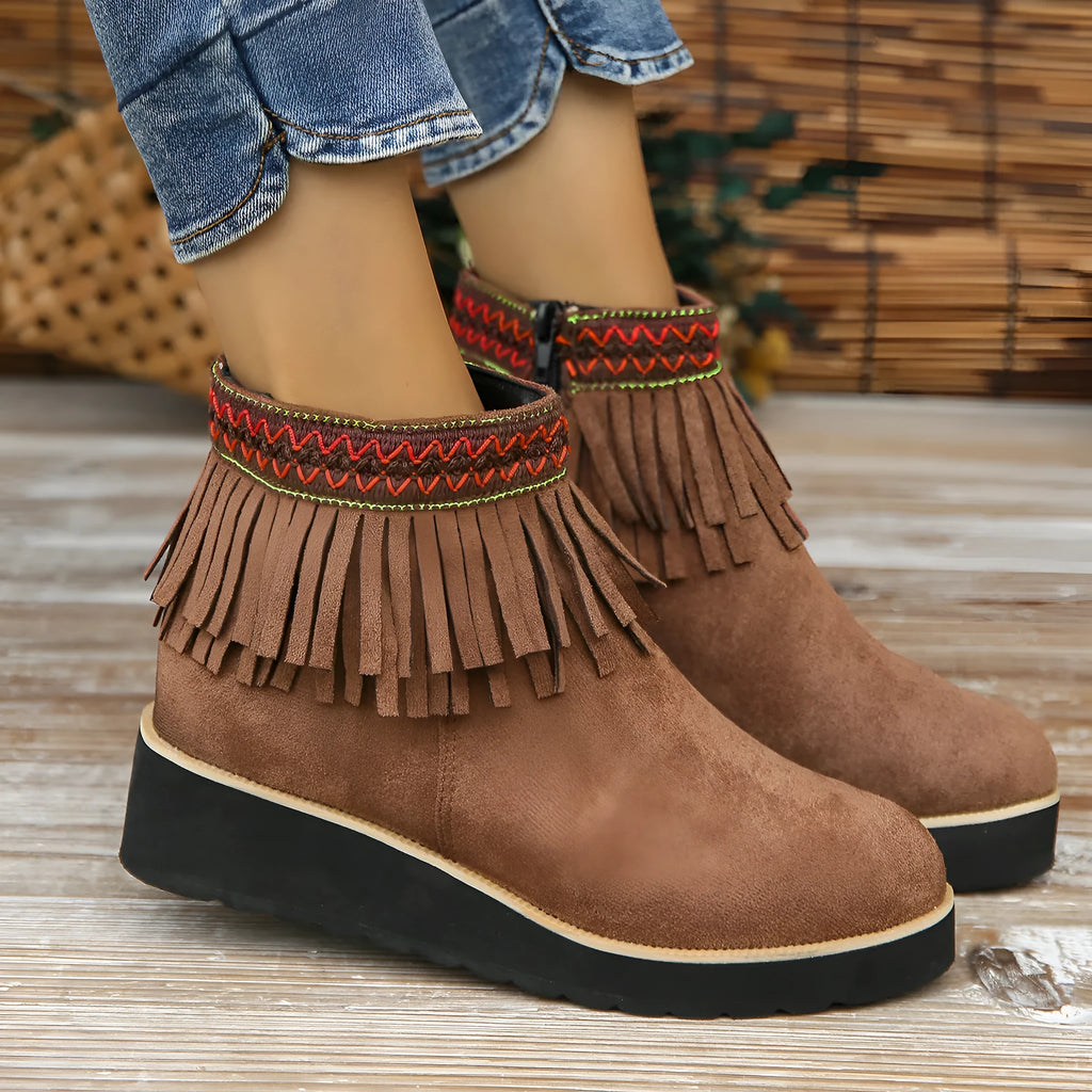 Women's dark brown suede ankle boots with a wedge heel, side zip, and decorative tassel detail.