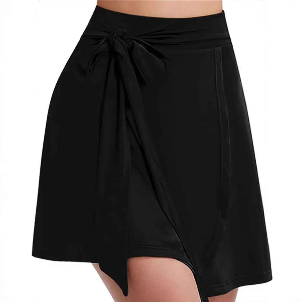 Black unisex thigh-length sports skirt with strap details and built-in shorts on a mannequin.