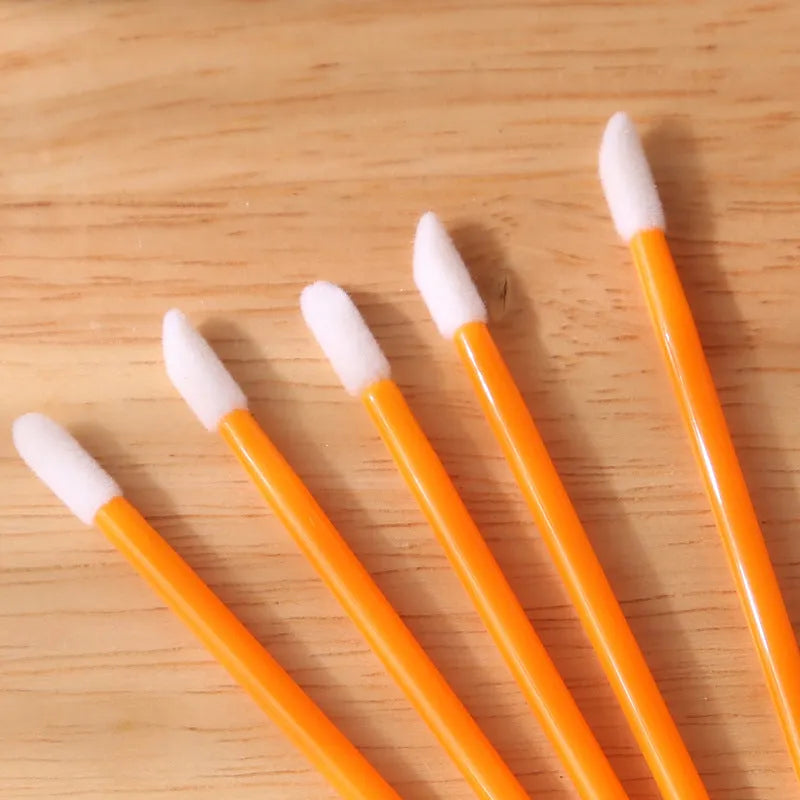 Disposable lip brush applicators with flocked heads in multiple handle colours on white background