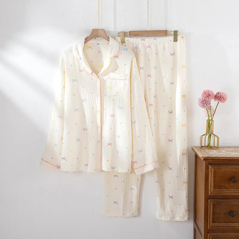 Women's beige long sleeve cotton pajama top and trousers set laid flat.