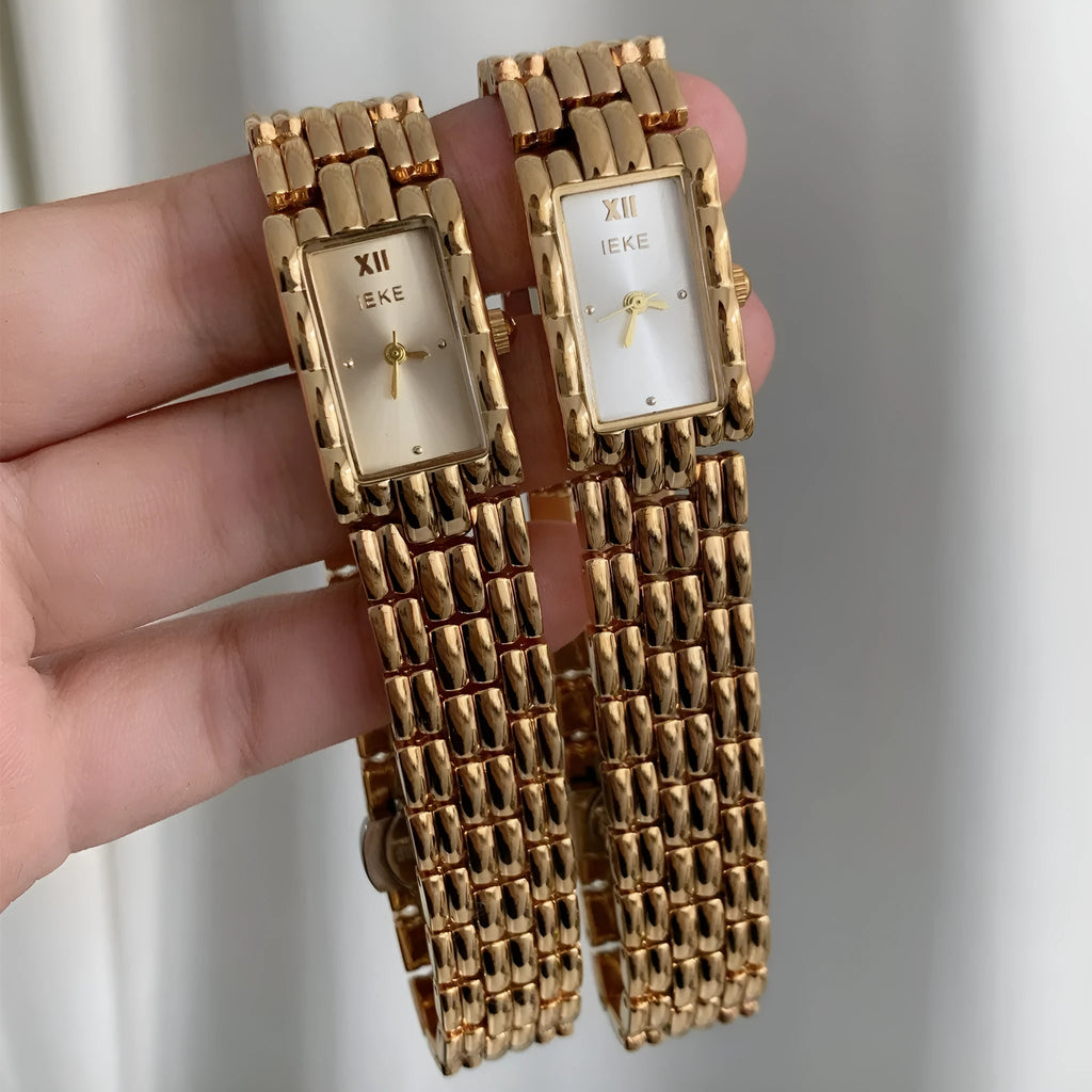 Women's silver and gold bracelet-style vintage watch with 15mm dial on wrist