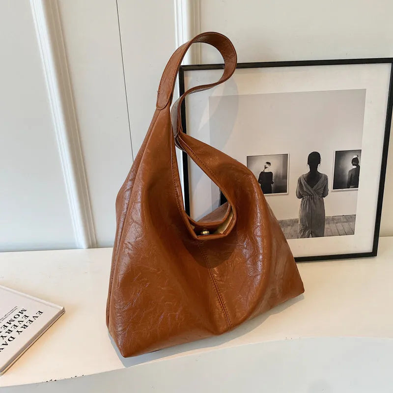 Soft leather shoulder bag in black with sandwich pocket design and shoulder strap