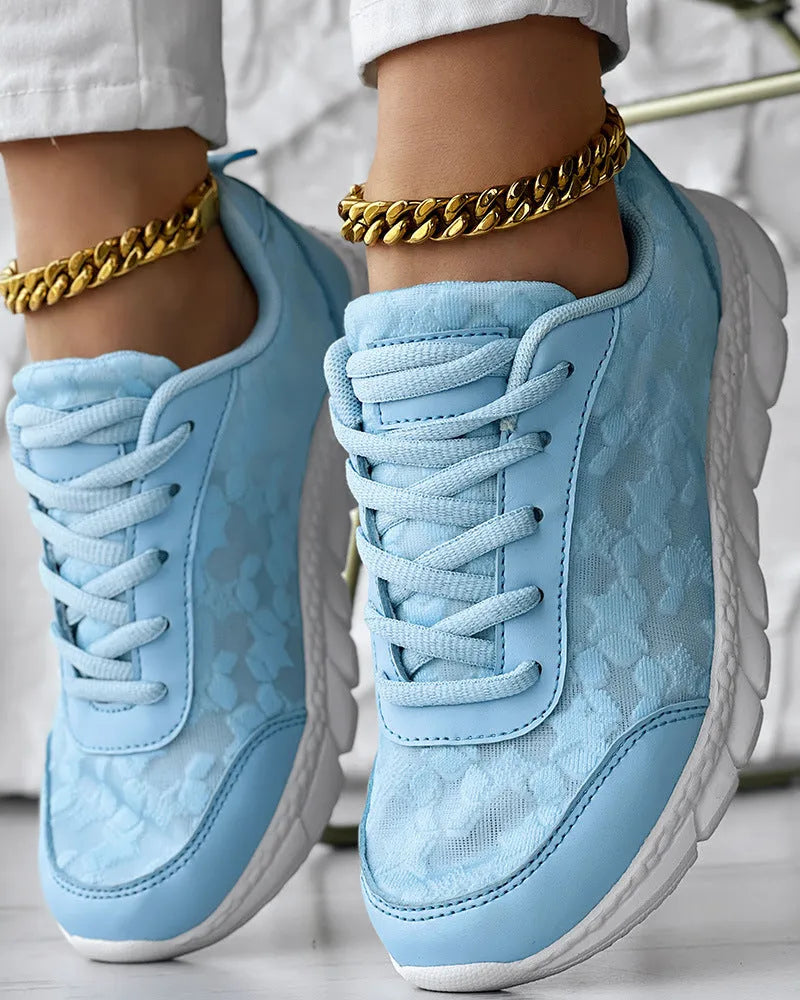 Women's white canvas casual sports running shoe with round toe and flat heel on a neutral background.