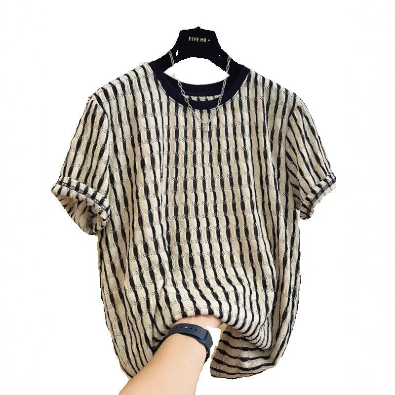 Man wearing a black and white striped loose casual short sleeve shirt made from linen and silk blend.