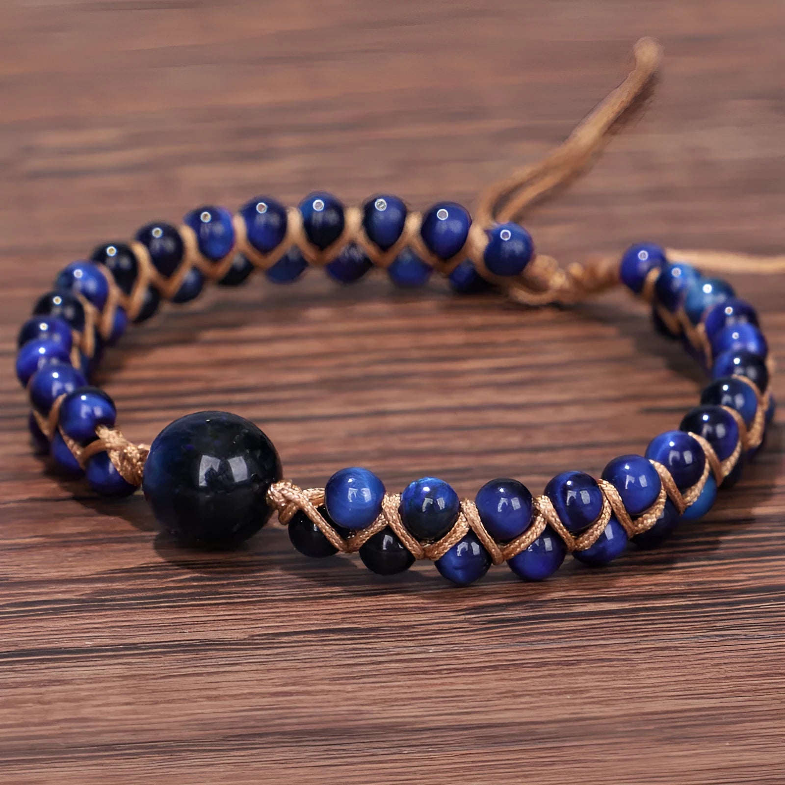 Handmade woven geometric bracelet with a blue Tigereye stone bead and pull design.
