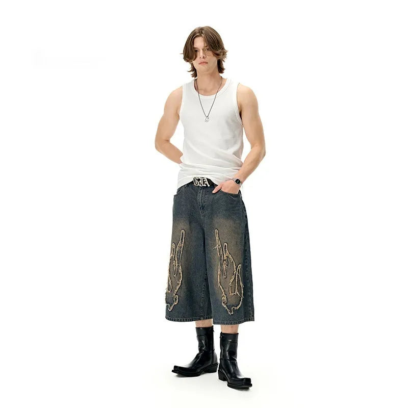 Men's black denim shorts with flame embroidery and cropped patch design on straight-leg cut