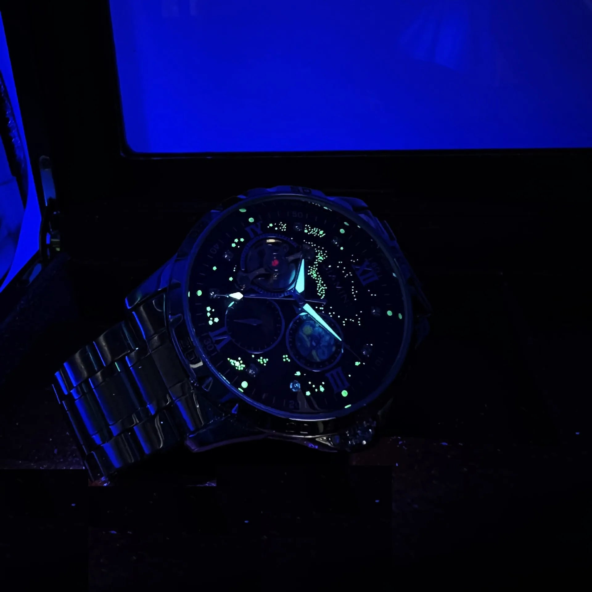 Automatic mechanical men's watch with large black dial and rose gold case, showing skeleton back.