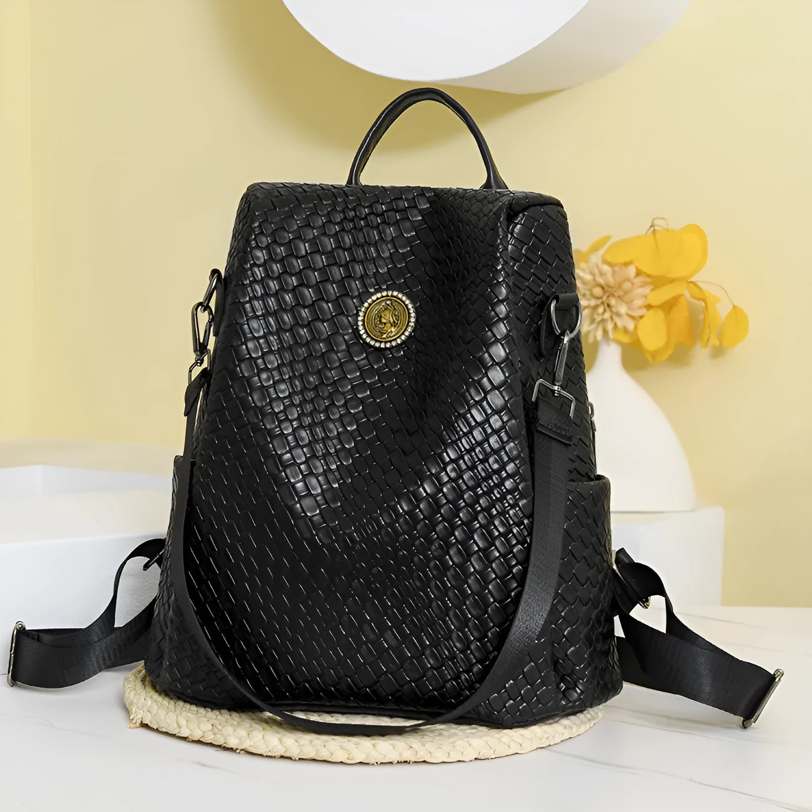 Women's black anti-theft backpack with woven detailing and multiple zipped compartments.