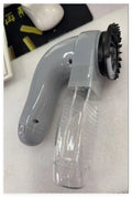 Gray portable electric pet hair remover with soft rubber head and collection canister.