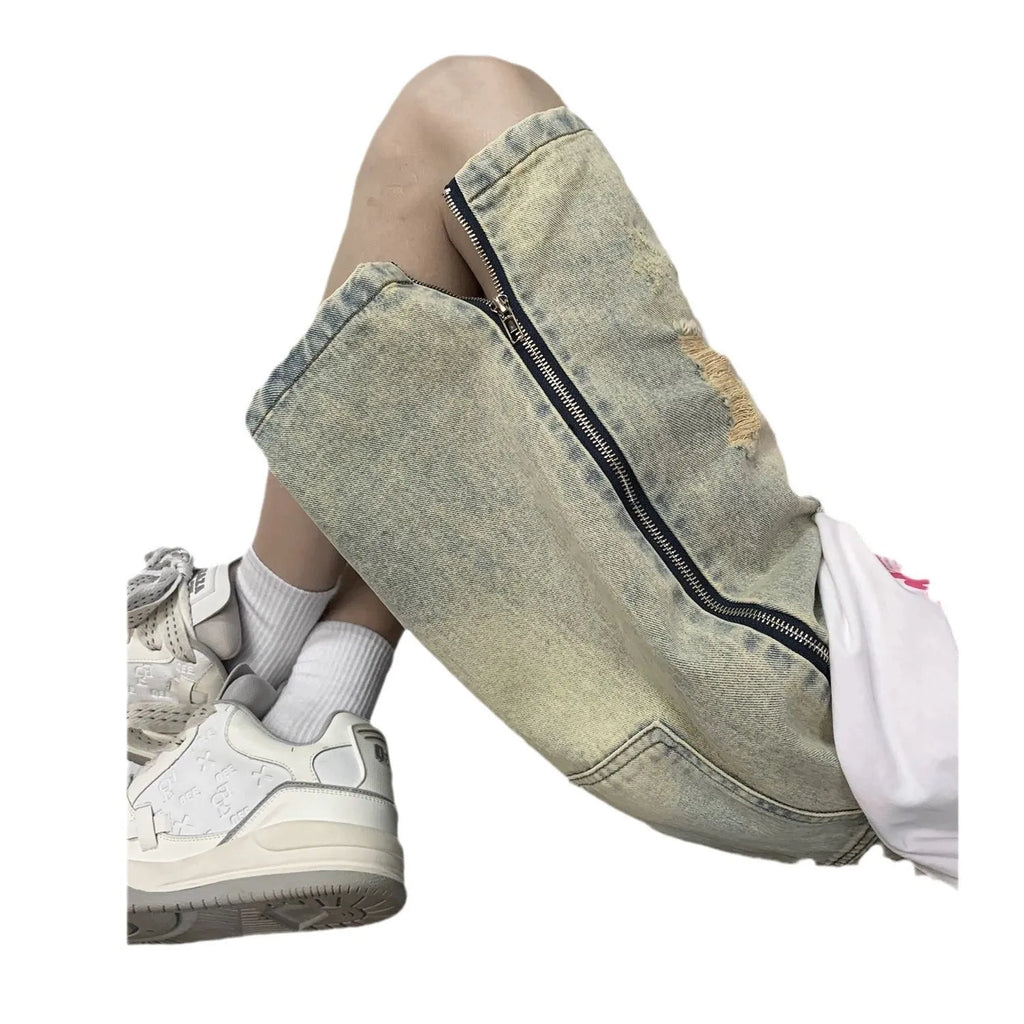 Men's blue denim shorts with yellow mud wash effect, ripping details, button fly, and loose straight-leg fit
