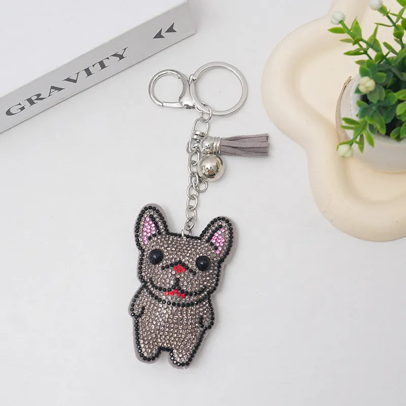 Close-up of a rhinestone dog charm keychain in a caramel colour with sparkling stones on a metal base.