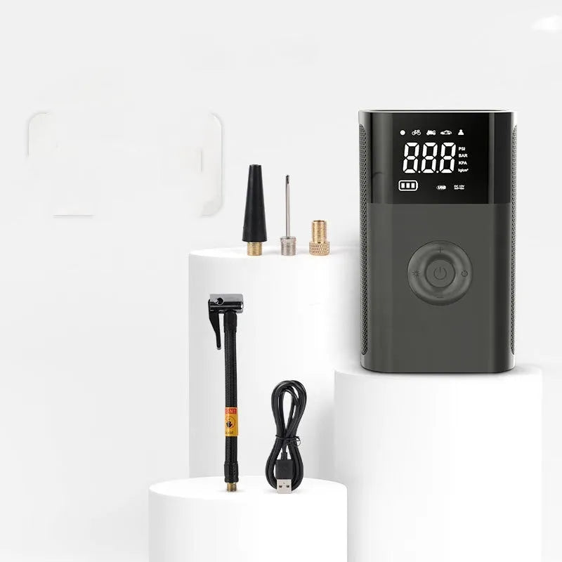 Wireless handheld digital display air pump with LED light and various nozzle attachments on a grey background.