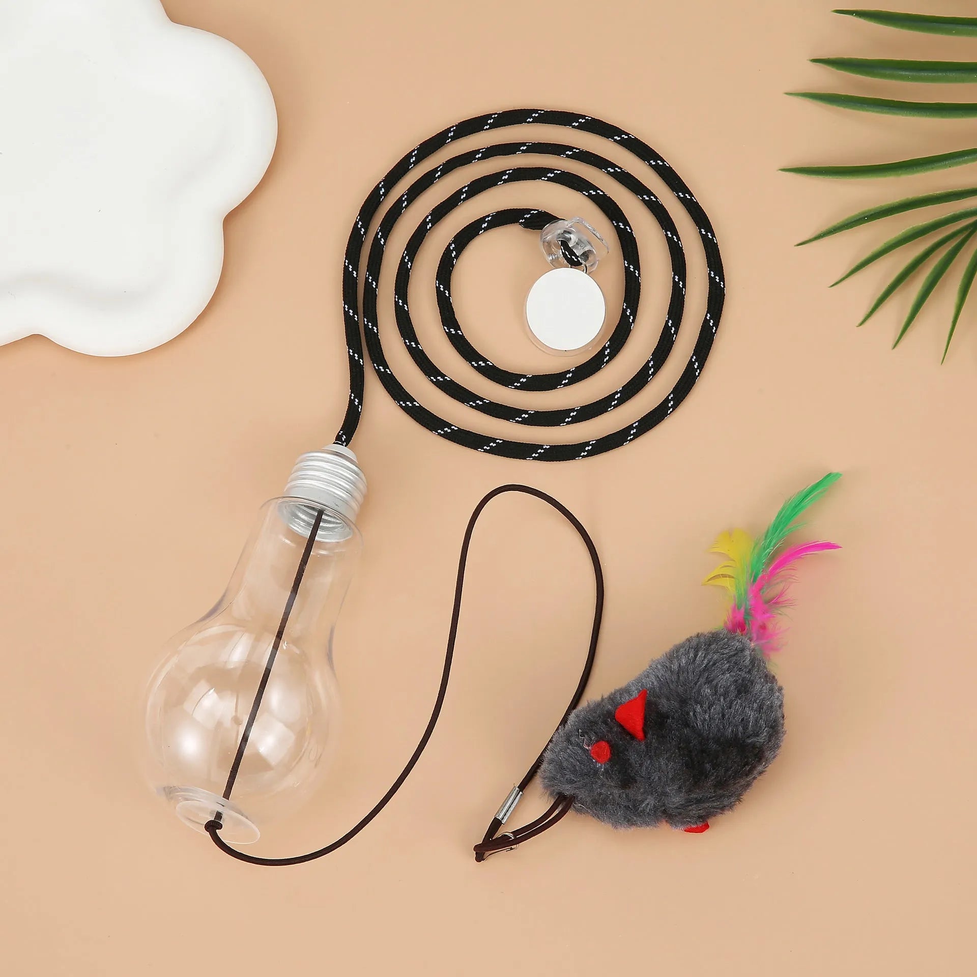Gray and yellow hanging interactive cat toy with treat dispenser extended on elastic rope
