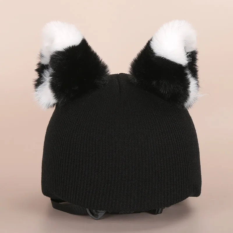 Plush fabric ski helmet decoration with cartoon design on a black ski helmet.
