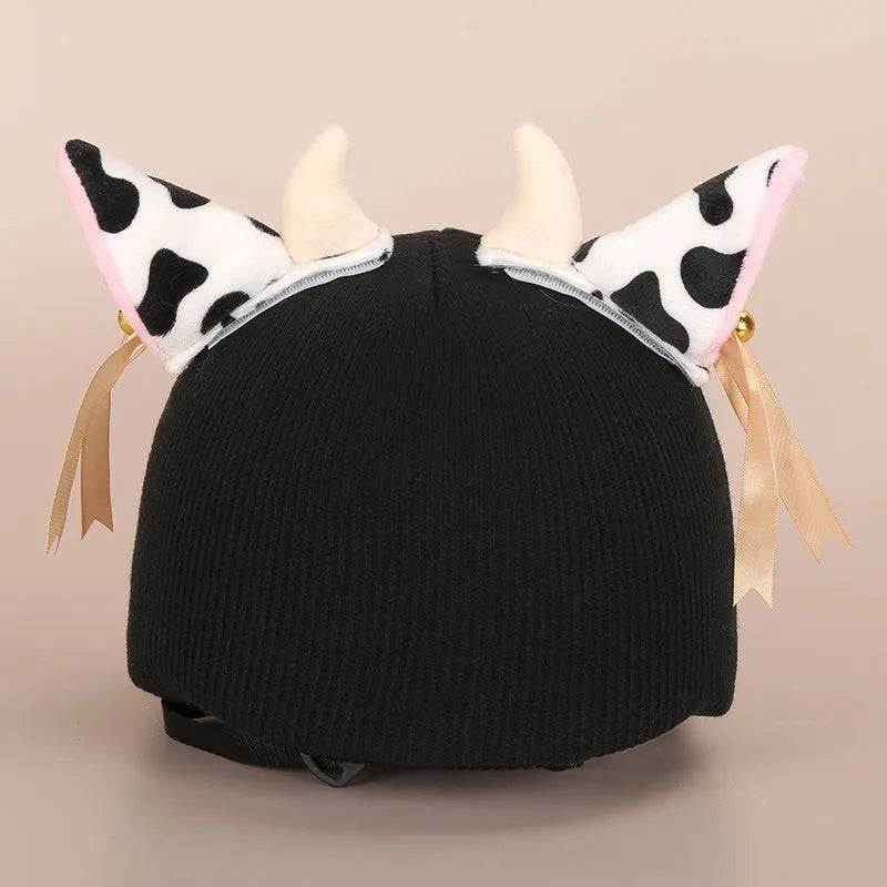 Plush fabric ski helmet decoration with cartoon design on a black ski helmet.