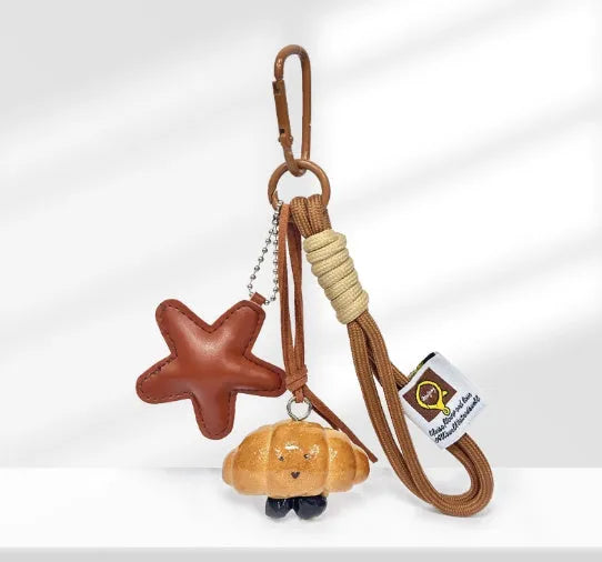 Handmade brown polymer clay soda bread charm on a brown strap, showing cartoon bread design details.