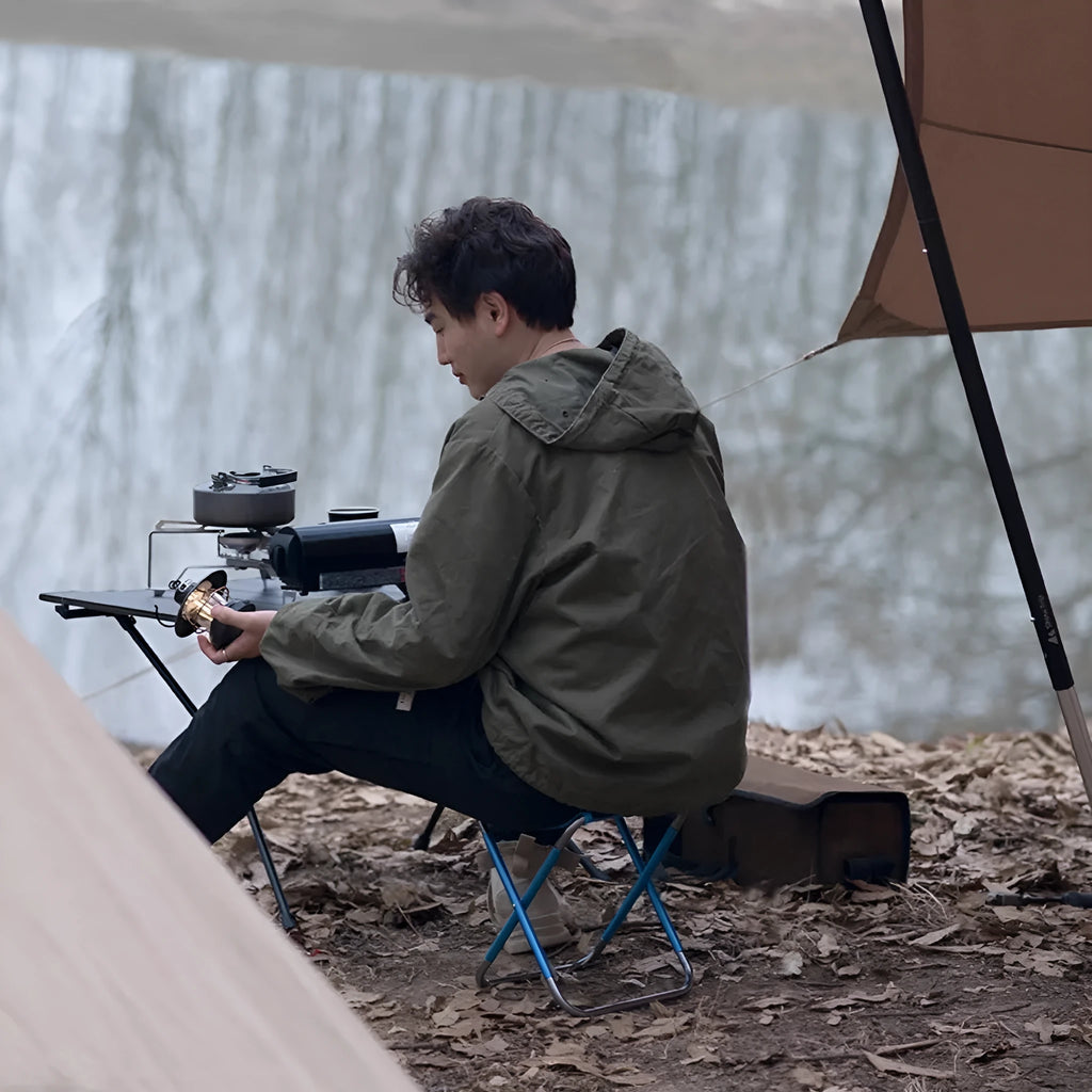 Black aluminium alloy folding stool in collapsed position for camping and outdoor use