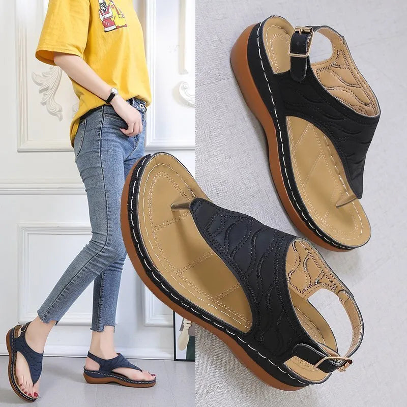 Women's black casual wedge heel flip flop sandals showing adjustable back buckle strap and solid colour design.