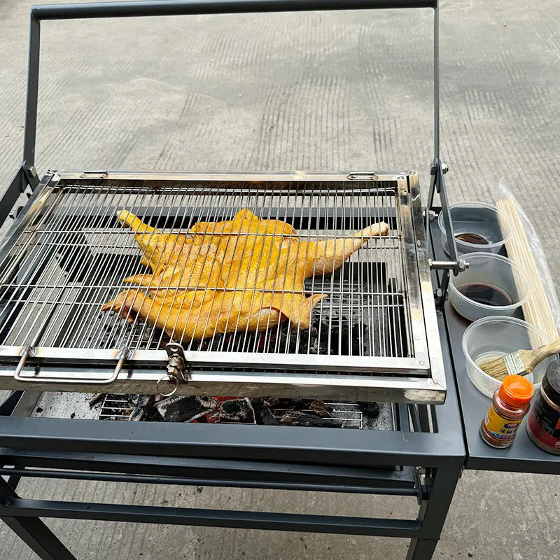 Large foldable L-size charcoal BBQ stove with grill, shown in a garden setting.