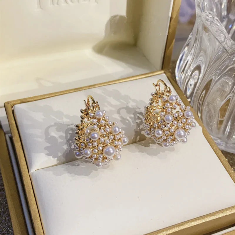 Gold-coloured copper earrings with a small bead flower basket design.