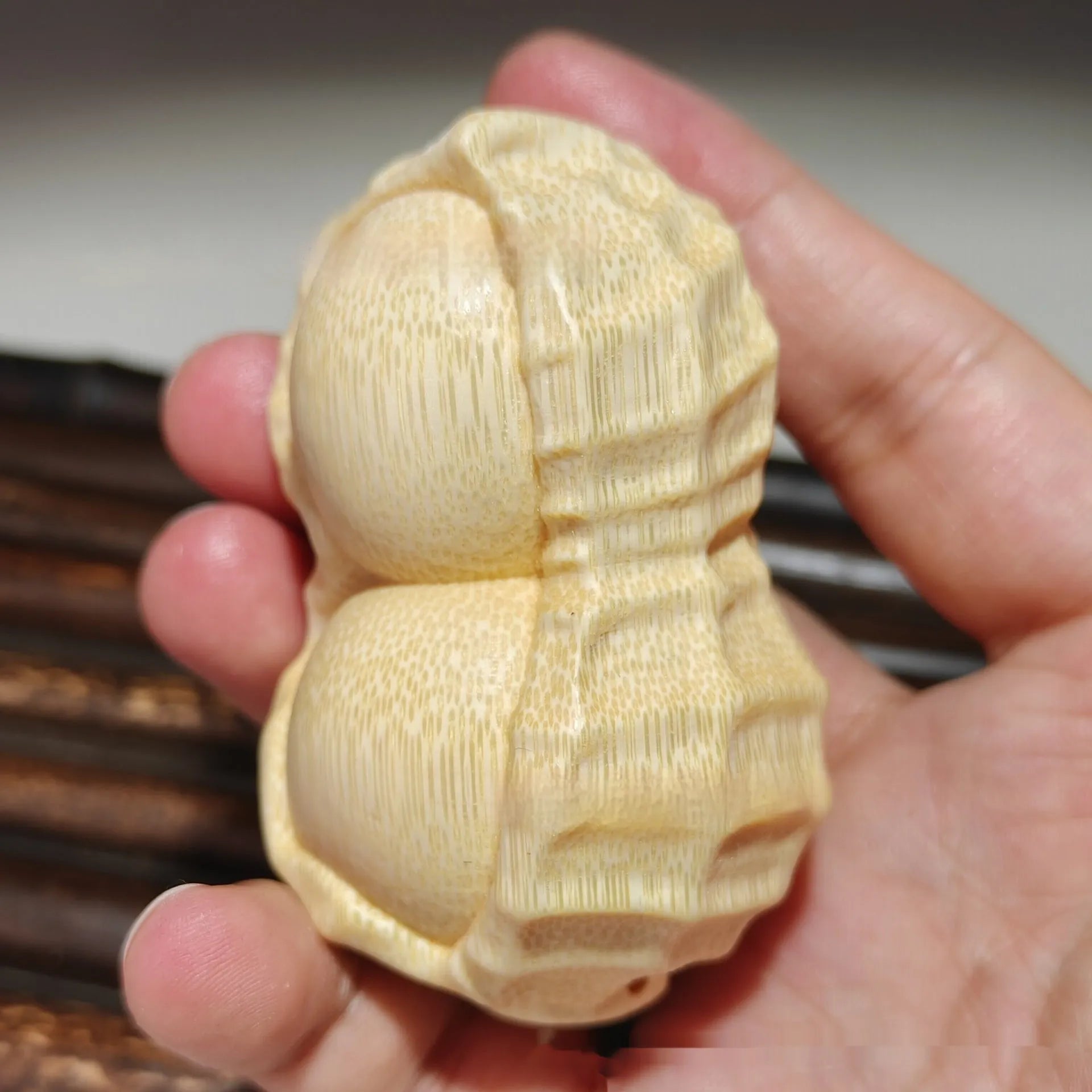 Carved solid bamboo peanut ornament in a modern simplicity style on a plain background.